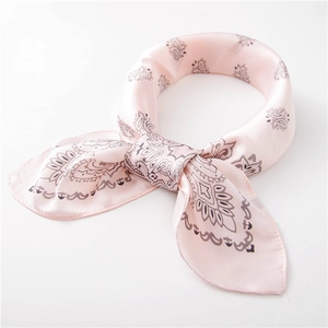 Detail of pink silk paisley scarf showing smooth texture and delicate knotted draping