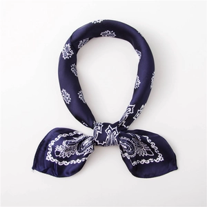 Detail of silk-texture navy blue paisley scarf showing elegant knot and smooth glossy finish