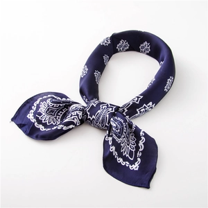 Detail of navy blue paisley silk scarf showing the elegant knot and satin texture