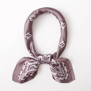 Detail of a purple paisley silk scarf tied in a neat ring knot with silky luster texture