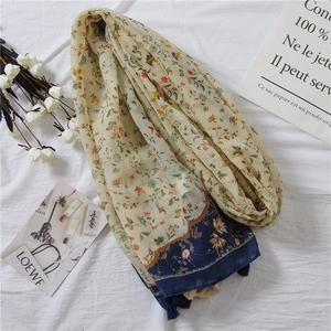 Floral print cotton linen scarf with blue tassels for women in a lifestyle setting