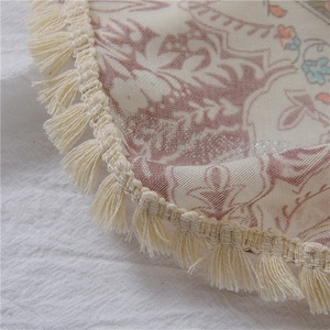 Detailansicht eines Boho-Schals mit Blumenmuster, Stickerei und eleganten beigen Quasten