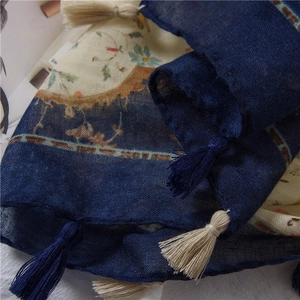 Detailed close-up of breathable floral cotton linen scarf with blue tassels and ethnic pattern