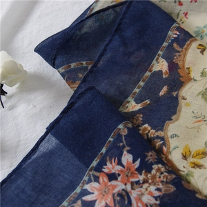 Detailed macro view of the floral print texture on the cotton linen navy blue scarf