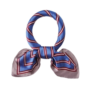 Carré de soie rayé bleu marine et rouge noué avec élégance en style de cravate