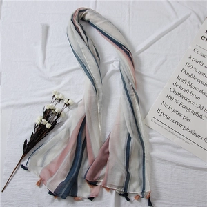 Detail of striped cotton linen scarf with soft tassels and minimalist floral props