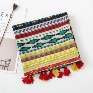 Detail of bohemian geometric shawl with colorful patterns and fringed tassel edges