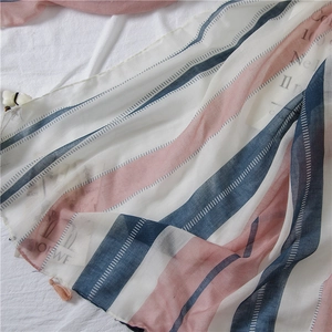 Detail of striped cotton linen scarf with navy, pink and white bands and fringe edges