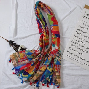 Détail d'une écharpe à motifs géométriques colorés avec pompons et texture douce