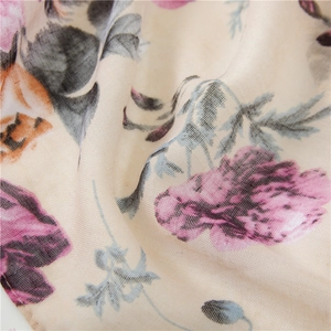 Close-up of pink floral print on soft breathable beige cotton linen scarf fabric