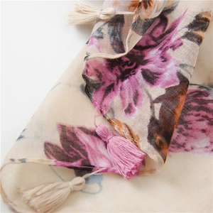 Detail of floral printed scarf showing delicate tassels and breathable cotton linen texture