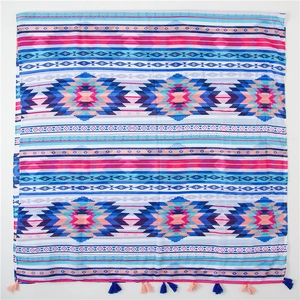 Close-up of geometric tribal patterns and fringe tassels on a cotton linen scarf