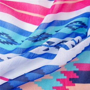 Macro view showing the detailed linen texture and colorful geometric patterns of the shawl