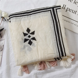 Detail of cream vintage shawl with black geometric patterns and pink tassel fringe