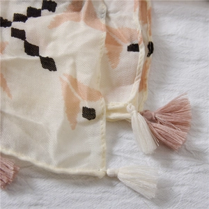 Detail of bohemian scarf with geometric prints and bicolor rose pink tassels