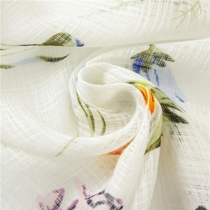 Close-up of semi-transparent cotton linen scarf with colorful floral patterns and mesh texture