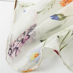 Macro detail of floral linen scarf showing breathable fabric texture and colorful flower print