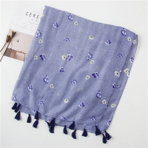 Detail of blue striped linen scarf with floral print and soft fringe tassels