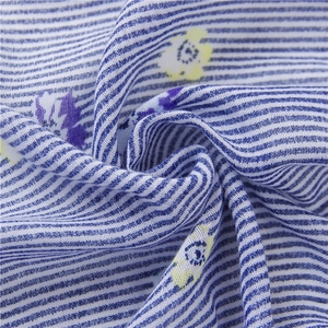 Close-up of blue and white striped linen scarf with yellow floral prints and soft texture