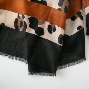 Détail d'une écharpe léopard avec texture à chevrons et bords à franges délicates
