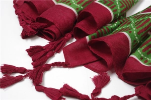 Close-up of deep red geometric jacquard shawl with detailed woven fringe tassels