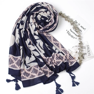 Detail view of tropical leaf print scarf with tassels on elegant white background