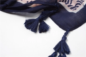 Close-up of navy blue scarf with geometric floral print and handcrafted tassel details