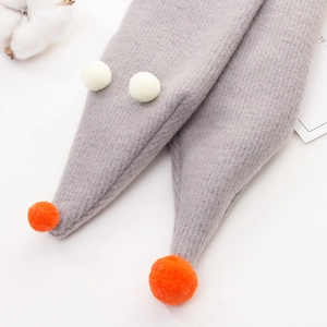Chunky knit kids scarf with white and orange pompoms on a clean white background