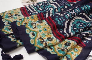 Detail of bohemian shawl with colorful geometric patterns and dark blue tassel fringe