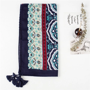 Close-up of bohemian navy blue cotton scarf with ethnic prints and handmade tassels