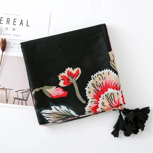 Dettaglio scialle in cotone nero con fiori, nappe e decorazione di fiori secchi