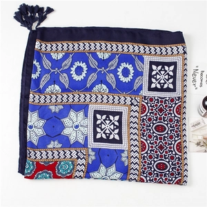 Detailed view of bohemian floral print shawl with navy blue tassels and mandala patterns