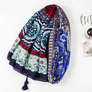 Close-up of bohemian style blue cotton scarf with colorful floral prints and tassel fringe