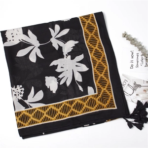 Detail of floral cotton linen scarf with mustard yellow geometric border and black tassels