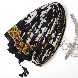 Detail of leaf print cotton linen scarf with black tassels and geometric patterns
