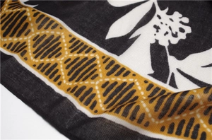 Detail of leaf print and geometric twill pattern on cotton linen scarf fabric