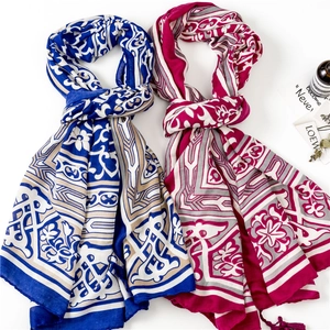 Vue détaillée du motif floral bohème sur écharpes bleues et roses avec franges fines