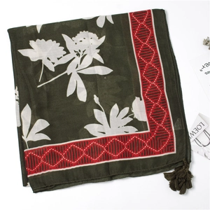 Detail of dark green floral cotton linen scarf with elegant tassels and geometric border
