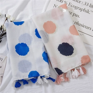 Close-up of cotton linen scarves with large colorful polka dots and fringe tassels