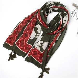Detail of floral and geometric print scarf with delicate green tassel fringe on edges