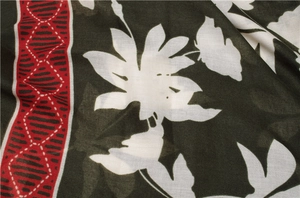 Detailed view of floral print scarf with green base, white flowers and red edges