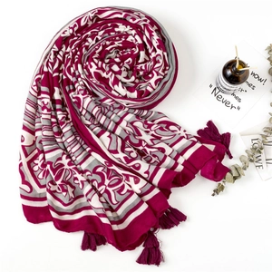 Détail d'une écharpe bohème aux motifs géométriques avec pompons et décoration