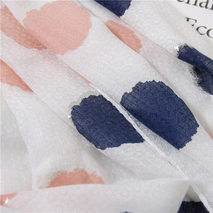 Macro view of cotton linen scarf showing pink and blue polka dots with silver edge and diamond weave