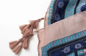 Detail view of ethnic floral scarf with pink tassels and cotton-linen texture
