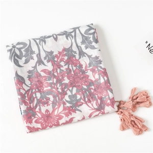 Close-up of floral print cotton scarf with delicate pink fringe tassels for summer