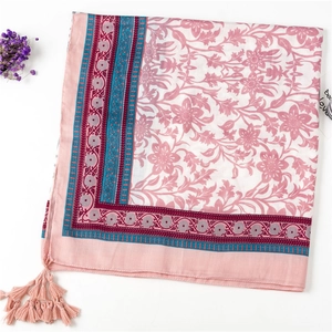 Detail of floral linen scarf with pink tassels and turquoise border trim