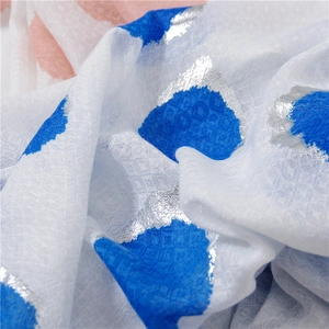 Close-up of cotton linen scarf with blue and orange foil dots and woven texture