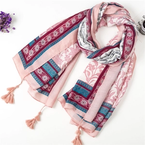 Detail of pink cotton scarf with bohemian patterns and decorative corner tassels