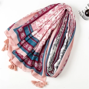 Detail shot of a pink floral cotton linen scarf with elegant tassels and boho print