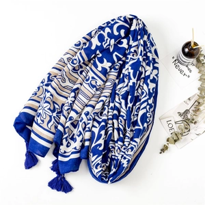 Détail d'un châle bohème bleu marine à imprimé floral avec des pompons à franges